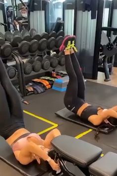 two women doing exercises on exercise mats in a gym with dumbbells and weight machines