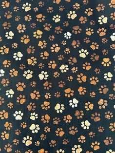 a black background with orange and white dog paw prints on the bottom half of it