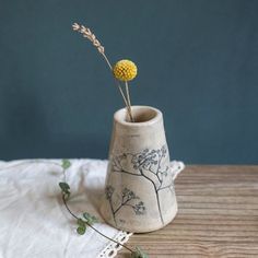 a small vase with a yellow flower in it