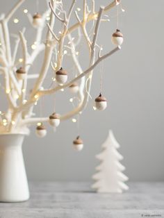 a white christmas tree with ornaments hanging from it's branches