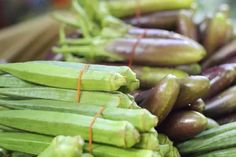 there are many green and purple vegetables on display