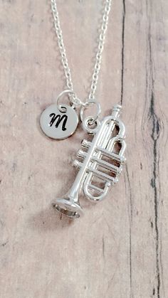 "This listing is for a hand stamped initial necklace featuring a 1 1/10\" x 3/5\" silver plated trumpet charm & 3/10\" stainless steel initial pendant. The silver plated chain is 18\" long, but can be made to your desired length- see last photo in listing. Please indicate the chain length you would like in the 'notes to seller' section at checkout. All items are lead & nickel free. Message me with any questions, thank you! Add an initial to any necklace: https://www.etsy.com/listing/1704 Trumpet Earrings, Trumpet Gifts, Trombone Necklace, Music-themed Pendant Necklaces As Gift, Silver Trumpet, Music-themed Pendant Necklace, Music Necklace, Music Jewelry, Band Jewelry