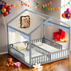 a child's bed with a tent on the floor and balloons in the background