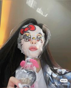 a woman with makeup on her face holding a water bottle in front of her face