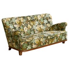 a floral couch sitting on top of a wooden frame