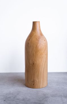 a wooden vase sitting on top of a cement floor