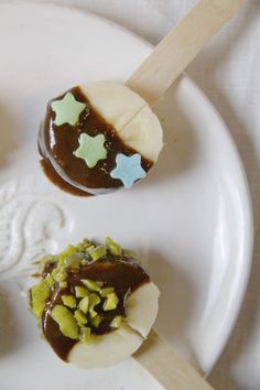 two desserts are on a white plate with wooden utensils in the shape of stars