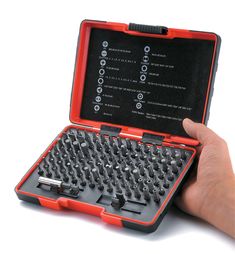 a hand holding an open laptop computer with many screws in the case on it