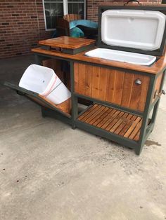 an outdoor cooler with two ice buckets on the top and one in the back