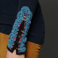 a close up of a person's hand with a crochet bracelet on it