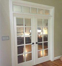 an empty room with two white doors and hard wood flooring on either side of the door