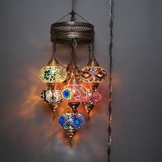 a chandelier hanging from the side of a wall with colorful lights on it