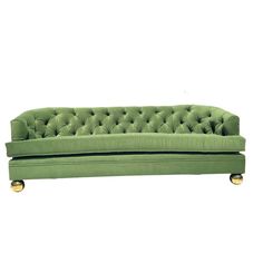 a green velvet couch with gold legs and buttons on the back, against a white background