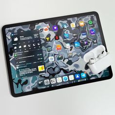 an apple airpods is attached to the back of a tablet with camo pattern on it