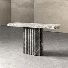 a marble table sitting in the middle of a room with concrete walls and flooring