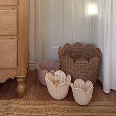 three wicker baskets sitting on the floor next to a dresser