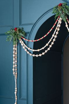 the door is decorated with beads and greenery