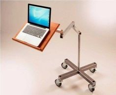 a laptop is sitting on top of a table with wheels and a wooden tray attached to it