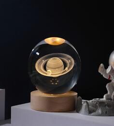 a glass ball sitting on top of a wooden base next to an elephant figurine