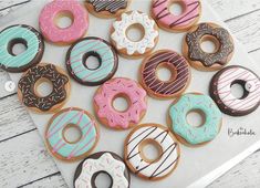 there are many donuts that are on the table together and one is pink, blue, green, white