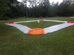 an inflatable ball and raft on the ground with trees in the backgroud