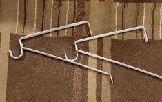 two metal clothes hangers sitting on top of a carpet