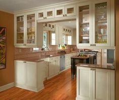 a kitchen with wooden floors and white cabinets