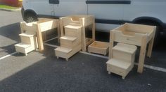 several unfinished wooden furniture sitting in front of a van