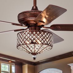 a ceiling fan with crystal chandelier hanging from it's blades in a living room