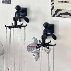 there are two pairs of shoes hanging from hooks on the wall, with chains attached to them