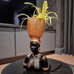 a statue with a basket on top of it's head sitting on a table