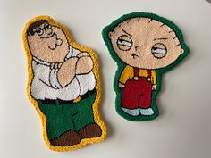 two embroidered patches depicting cartoon characters, one with glasses and the other with green pants