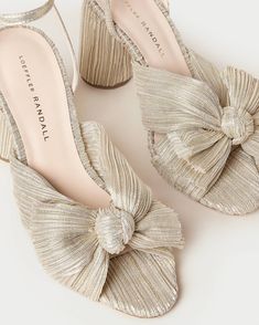 Heeled sandal in a shimmery off white/champagne platinum pleated lamé fabric topped with our signature pleated bow. Padded footbed with gold stamped logo. Open toe with adjustable buckle ankle strap. 3.5 inch heel. Bow Mules, Loeffler Randall Shoes, Low Heel Sandals, Bow Sandals, Bow Heels, Beautiful Gift Wrapping, Heeled Sandal, Loeffler Randall, Leather Pieces