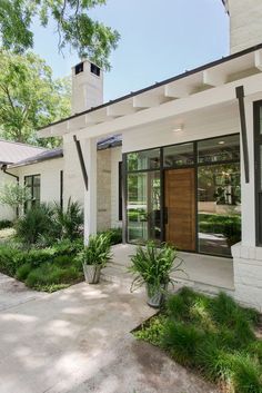 a white house with black trim and wood door