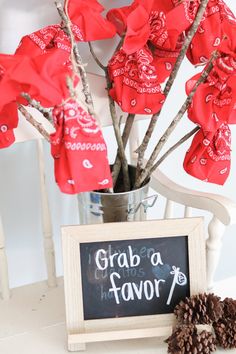 red flowers in a vase next to a chalkboard