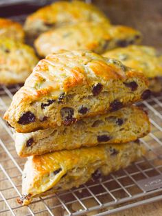 three scones stacked on top of each other on a wire rack with cheese and raisins