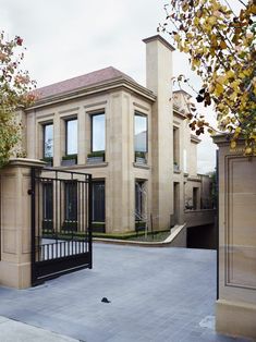 an entrance to a large house with a gate in the front and two story building behind it