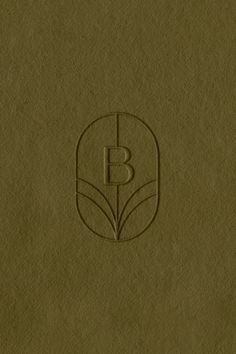 the letter b is inscribed on top of a brown paper with a leaf design in it