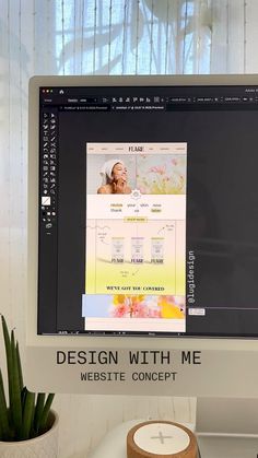 a desktop computer monitor sitting on top of a desk next to a potted plant