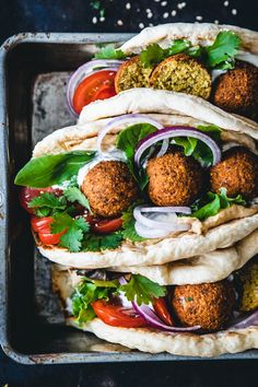 falafe wrap with meatballs and vegetables on it in a baking pan, ready to be eaten