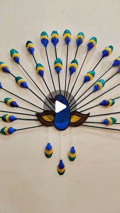 a peacock clock with blue, yellow and green feathers on it's back side