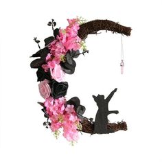 the letter c is made up of flowers and branches with a cat on it's back