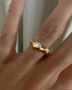 a woman's hand with a gold and diamond ring