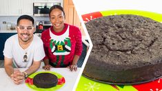 a man and woman sitting in front of a chocolate cake on a green platter