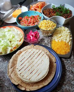 a table topped with lots of different types of food and bowls filled with salads