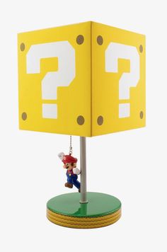 a lamp that has a mario mouse hanging from it's base with a question mark on it