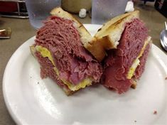 a corned beef sandwich cut in half on a plate