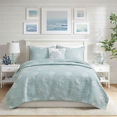 a bed with blue comforters and pictures on the wall