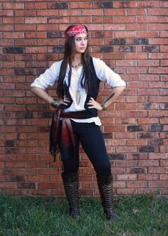 a woman standing in front of a brick wall with her hands on her hipss