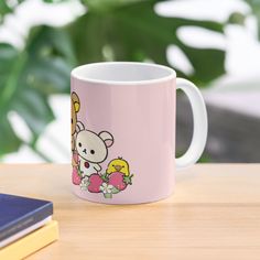 a pink coffee mug with a cartoon giraffe and flowers on the side sitting on a table